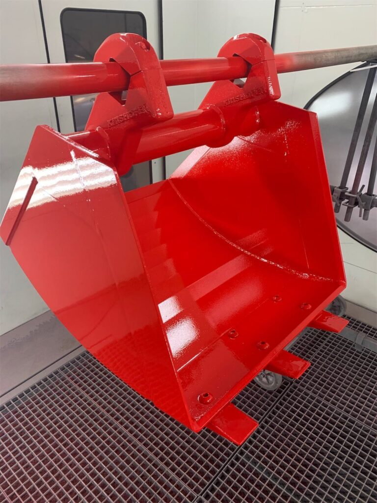 Industrielackierung – rot beschichtetes Bauteil in der Lackierkabine